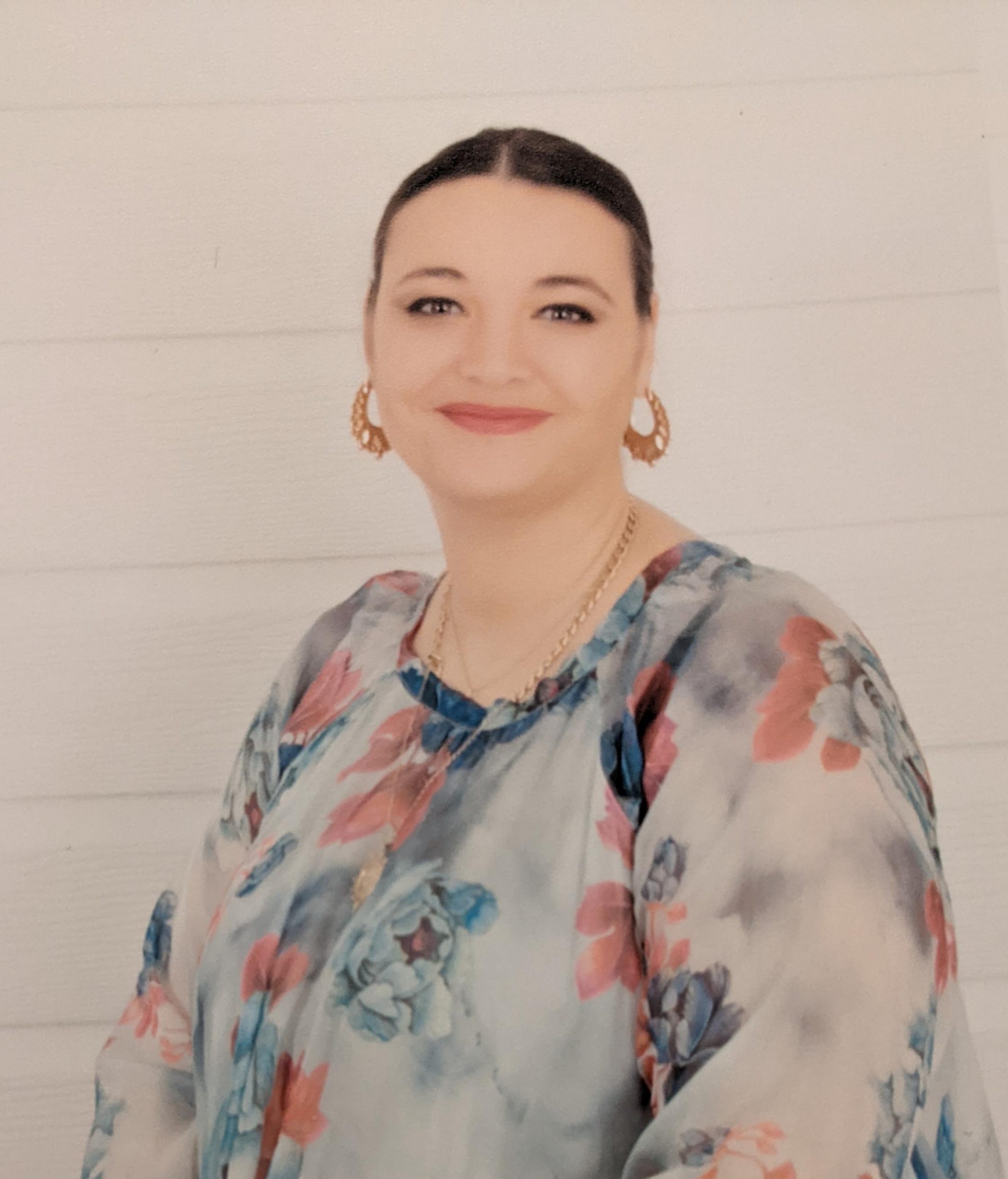 Headshot of South West London SLC member, Nikki Hughes. Nikki is seated, against a cream background. She is sitting at an angle, but facing the camera and smiling.