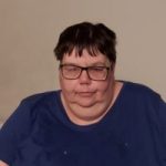 Photo of South Yorkshire SLC member, Helen Stirland. She is wearing a dark t-shirt and glasses, and is facing the camera, seated.