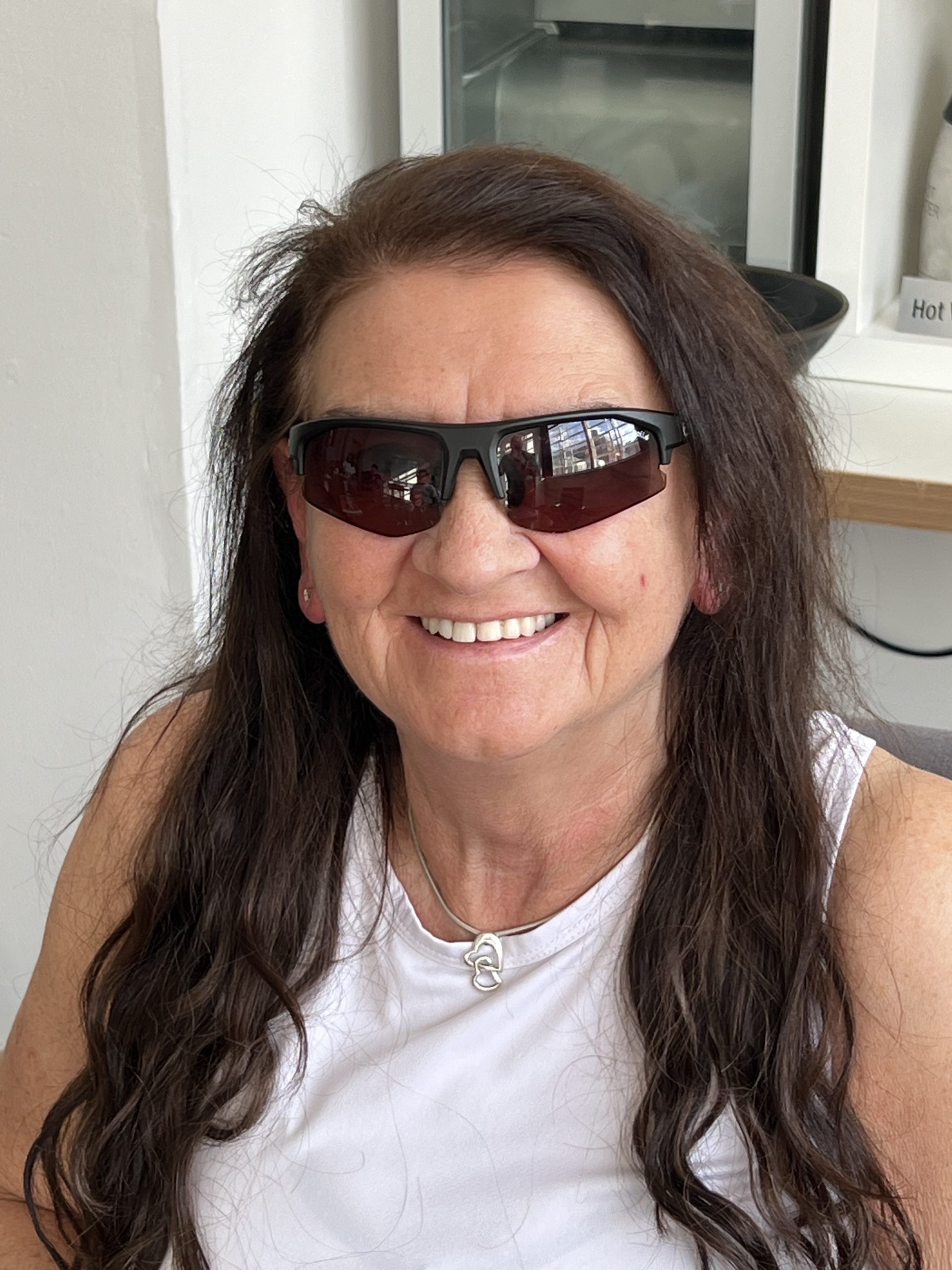 Headshot of Janiece, South Yorkshire SLC member. She has long dark hair and is wearing sunglasses. She is smiling at the camera.