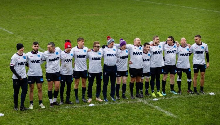 David Parfett standing with the England VI rugby team on a rugby pitch. They are wearing white rugby t-shirts and black shorts.